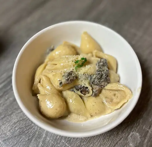 Pasta dish covered in a layer of thyme cream sauce and wild foraged Morel mushrooms.